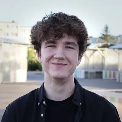 Uśmiechnięty Bartosz Gotowski patrzący wprost w
obiektyw